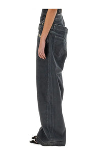 The Attico women’s long pants in navy blue grey feature dark-wash denim with wide-leg cut and visible stitching details