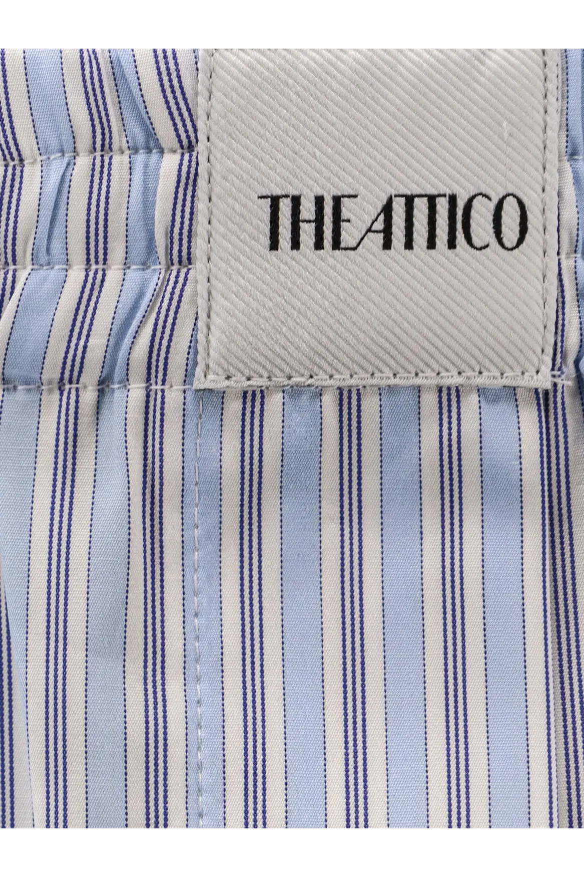 The attico women’s striped cotton shorts white feature a light blue and white striped shirt with fine navy vertical stripes