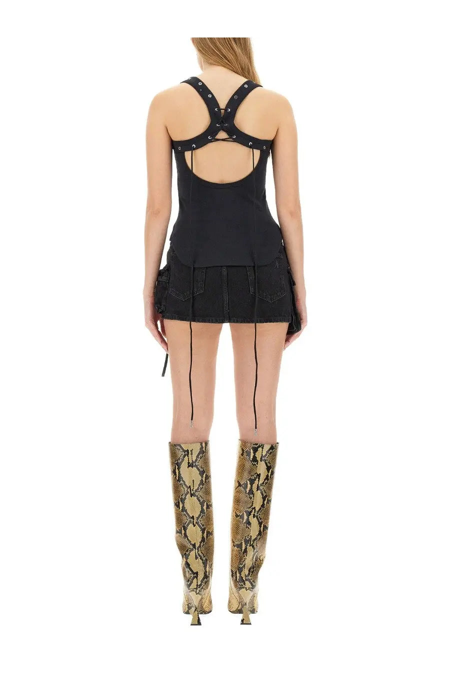 Black denim mini skirt with cross-back straps and side ties shown from the back by the attico women’s tops black collection