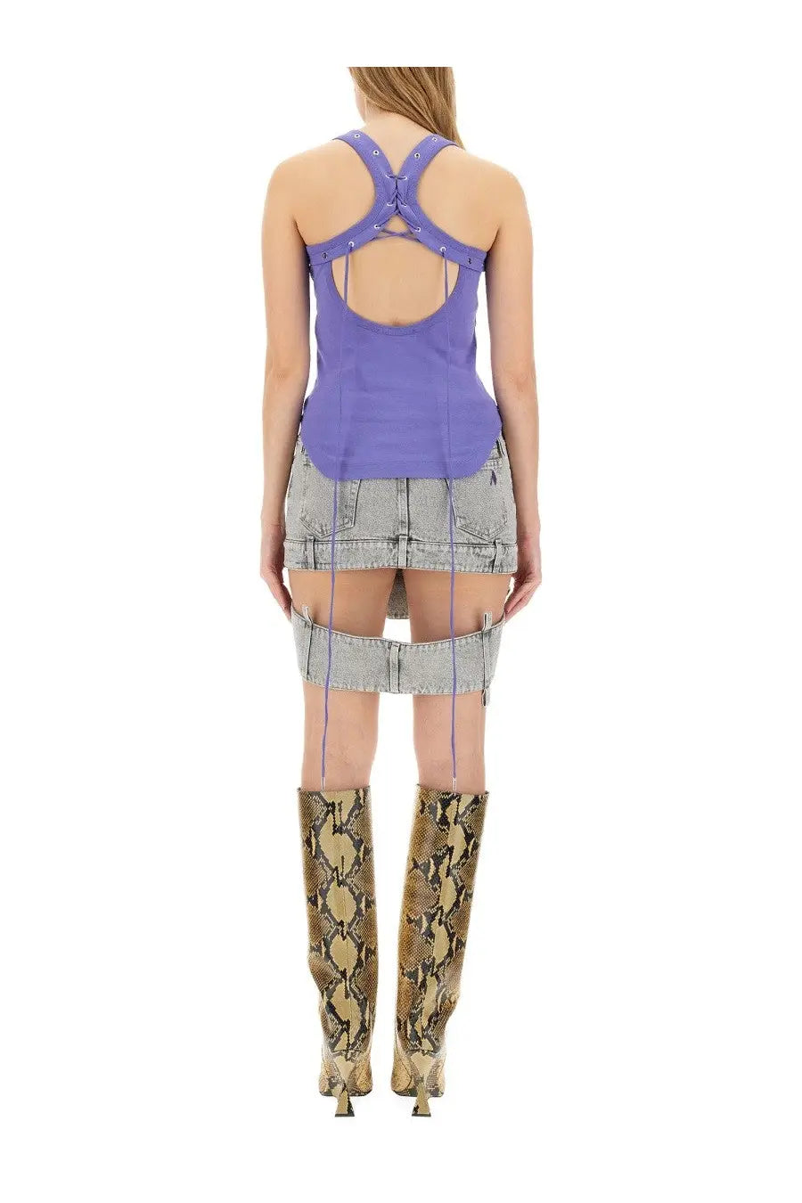 The attico women’s purple crisscross-back tank top styled with a denim skirt and snake-print boots shown from the back