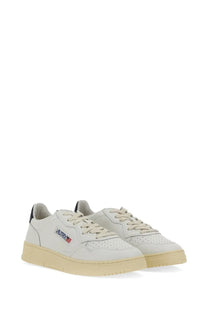 Autry men’s medalist low sneaker in cream-colored suede with subtle side logo and black heel accents