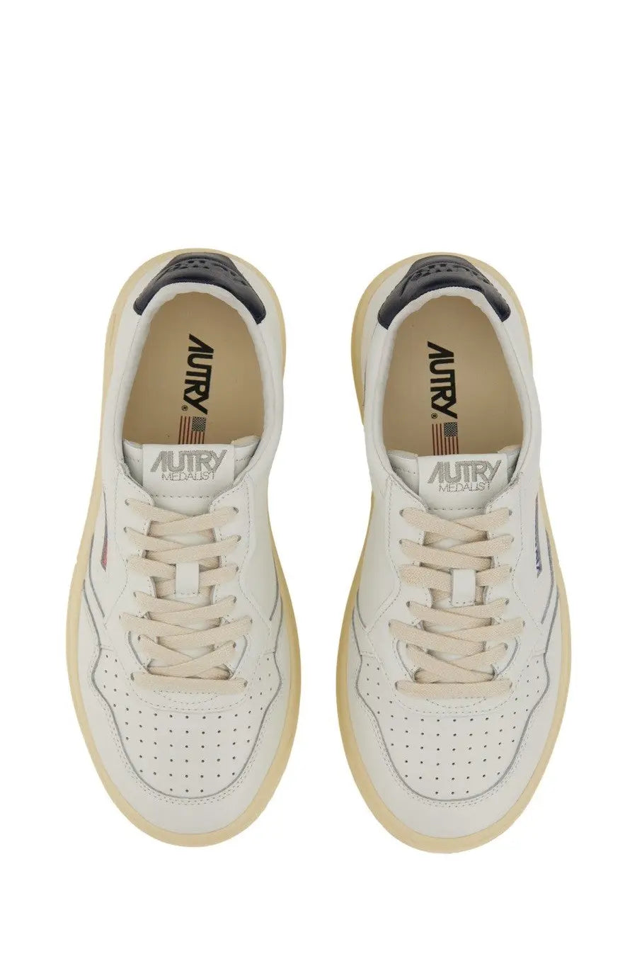 Autry men’s Medalist low sneaker white with white leather upper beige rubber soles and black heel tab accents viewed from back