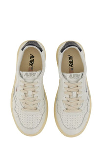 Autry men’s Medalist low sneaker white with white leather upper beige rubber soles and black heel tab accents viewed from back