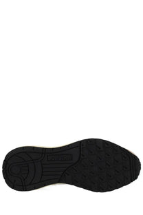 Black rubber sole with textured tread and adidas logo embossed near heel of autry mens reelwind low sneakers beige back side