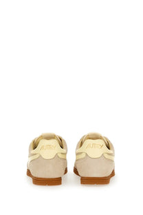 Beige suede autry men’s windspin sneaker with tan rubber sole and cream branding on the heel back side view