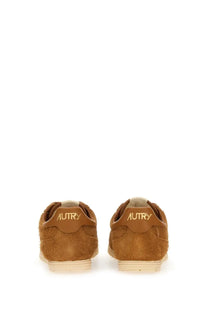 Back view of autry men’s windspin sneaker tan suede with light beige rubber sole and gold embroidered heel branding