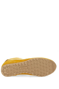 Back view of autry men’s windspin sneaker in yellow suede with tan rubber sole and geometric tread pattern