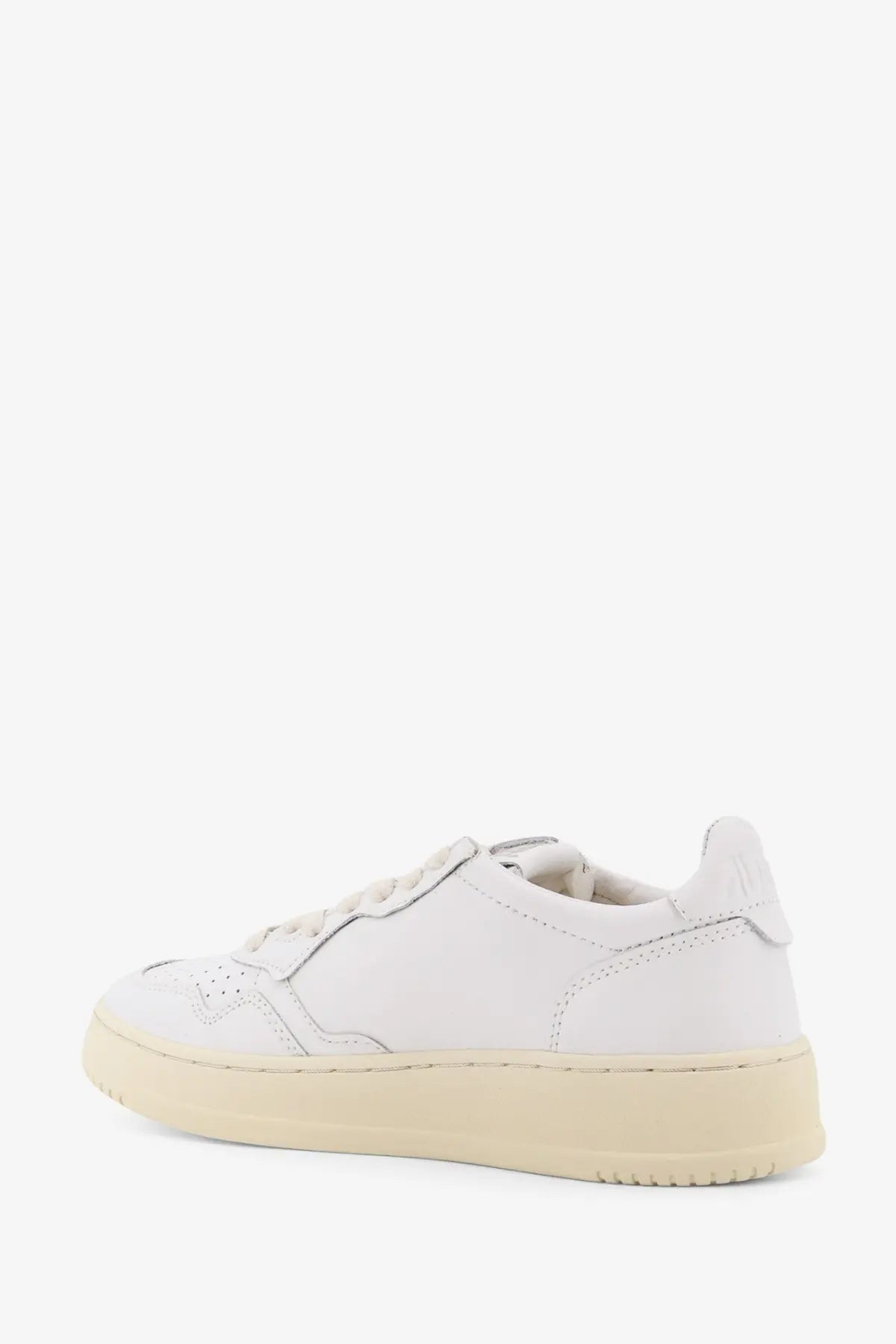Autry women’s medalist white leather low-top sneaker with cream rubber sole and perforated toe detailing