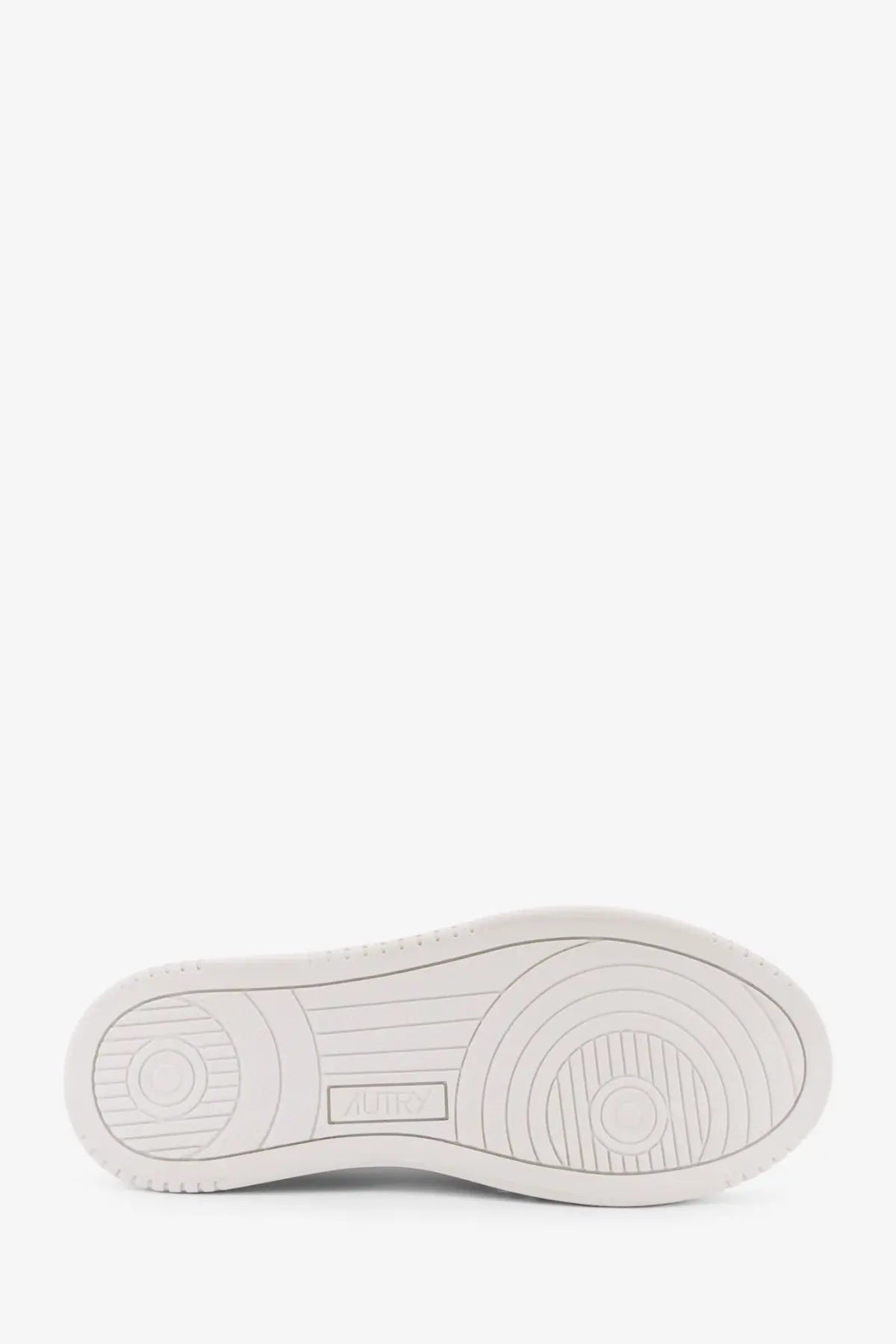 White rubber sole with circular tread patterns and embossed brand logo on autry women’s medalist low leather sneakers