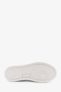White rubber sole with circular tread patterns and embossed brand logo on autry women’s medalist low leather sneakers