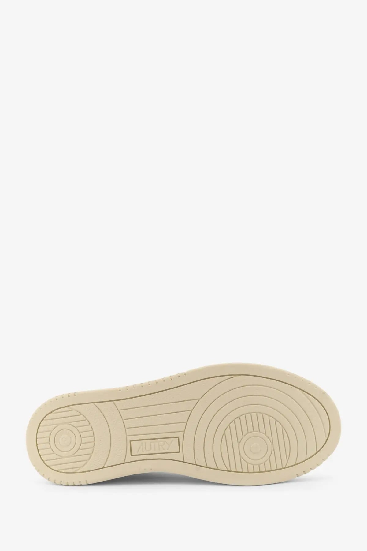 Beige rubber sole with concentric circular tread patterns and rectangular brand logo on autry women’s white leather sneakers
