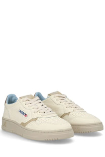 Cream-colored suede and canvas autry women’s medalist low sneaker with light blue lining and subtle logo patch on side