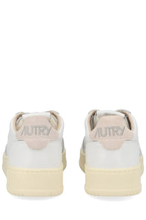 Back view of autry women’s medalist low sneaker white with beige suede heel tab and silver embroidered brand name