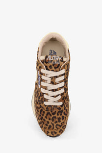 A tan and black leopard print suede sneaker with white laces from autry women’s reelwind low animal print pattern