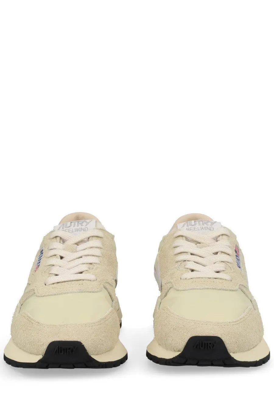 Back side of autry women’s reelwind low sneaker pink in beige suede and canvas with white laces and black soles