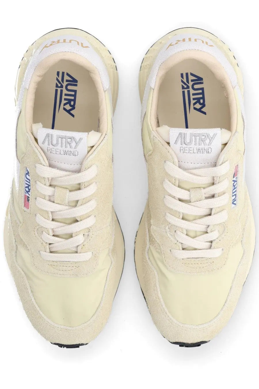 Autry women’s Reelwind low sneaker in cream-colored suede and canvas with white laces and navy branding on tongue and heel