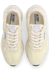 Autry women’s Reelwind low sneaker in cream-colored suede and canvas with white laces and navy branding on tongue and heel