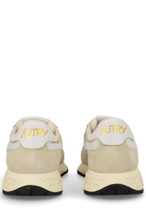 Back view of autry women’s reelwind low sneaker in cream suede with gold branding and black rubber sole