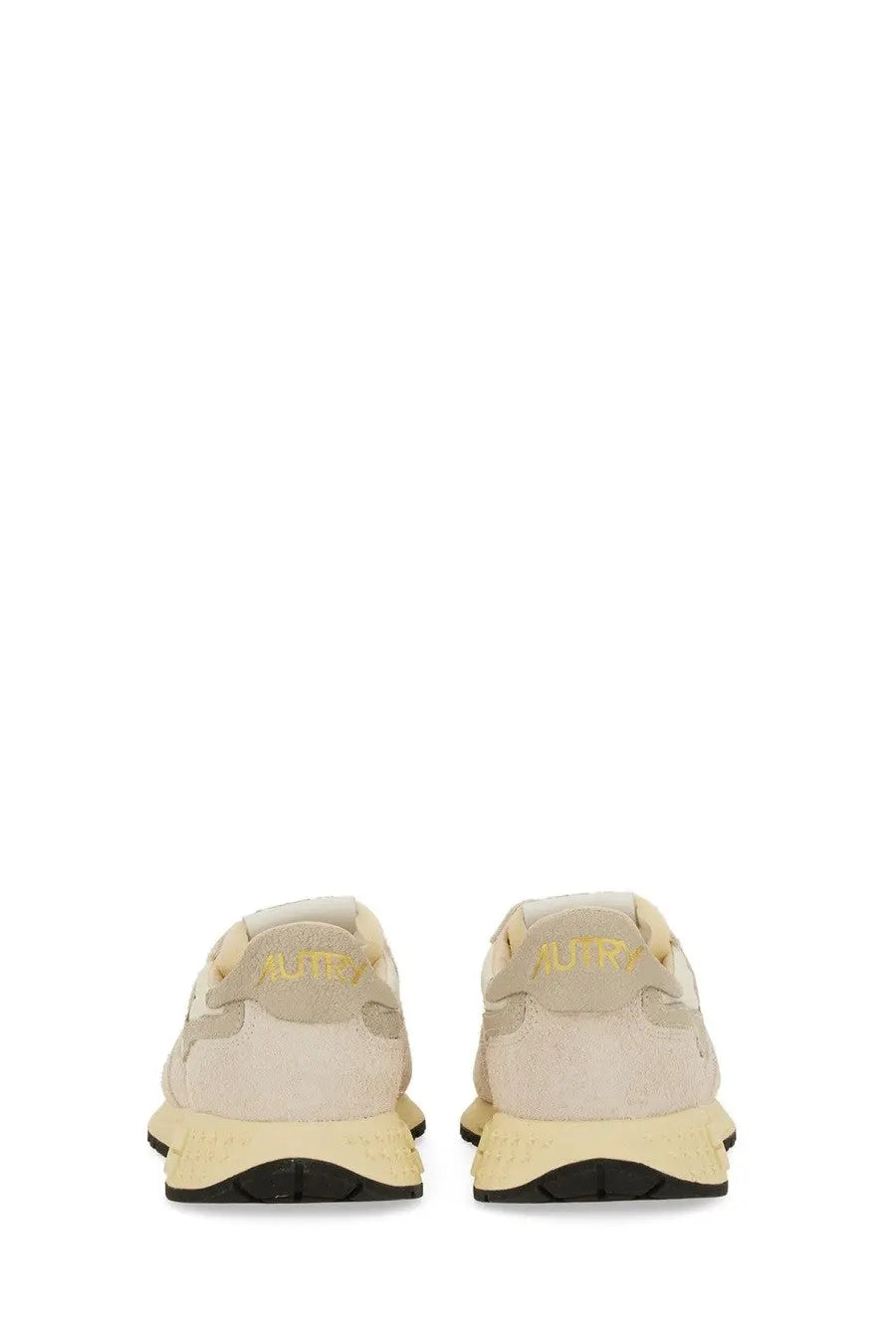 Back view of autry women’s reelwind low sneaker in beige suede and mesh with pale yellow rubber sole and gold branding