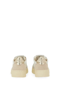 Beige autry women’s sneaker medalist low with metallic gold heel tabs and chunky rubber sole shown from the back side