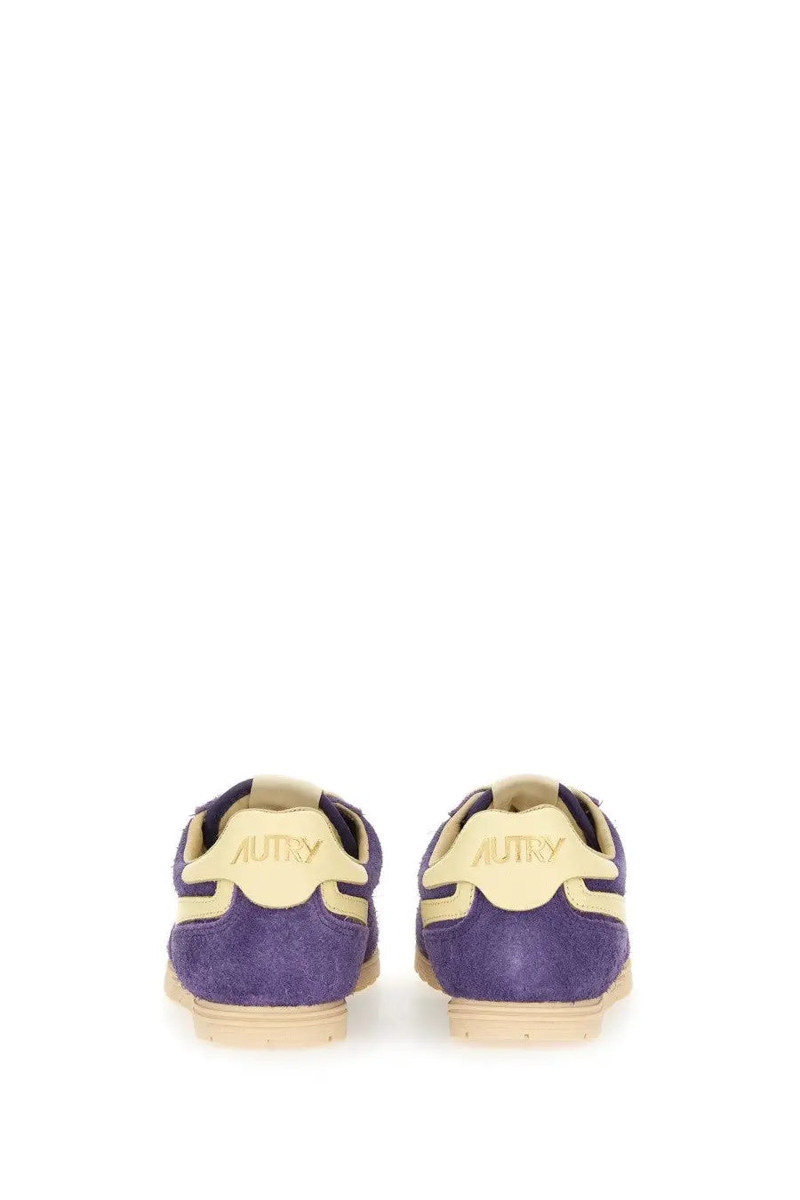 Back view of autry women’s windspin low sneaker in purple suede with cream accents and autry logo on heel
