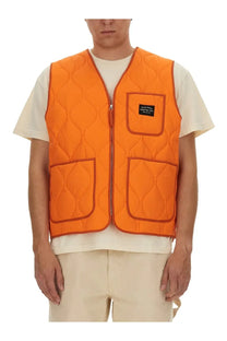 Awake Ny men’s bright orange quilted vest with central zipper three pockets and red stitching along seams