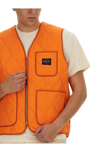 Awake Ny men’s bright orange quilted vest with central zipper, two front pockets, and black label on upper pocket