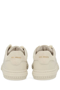Back view of cream-colored suede axel arigato men’s atlas sneaker with chunky sole and gold-tone branding on heel