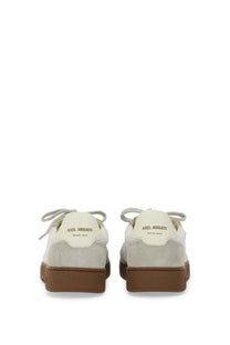 Cream-colored suede low-top axel arigato men’s says toe sneaker with brown rubber soles and matching laces back view