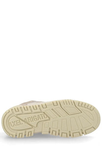 Beige rubber sole of axel arigato men’s sneaker area with embossed shield-shaped logo on the back side