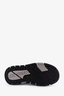 Black rubber sole with silver metallic branding and textured tread pattern on women’s axel arigato leather sneaker