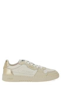 Cream-colored axel arigato women’s low-top sneaker with metallic gold accents perforated leather upper and white laces