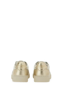 Axel Arigato women’s sneaker says white with gold metallic leather and white rubber soles in a sleek minimalist design