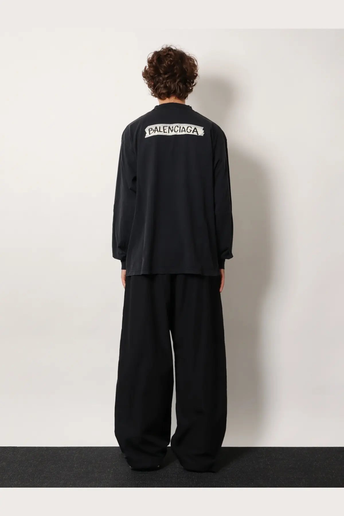 Balenciaga men’s black cotton long-sleeved shirt showing the white logo on the back side