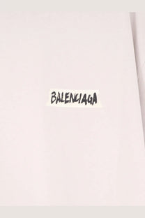 A white balenciaga sticker with black handwritten lettering on a white cotton balenciaga men’s shirt