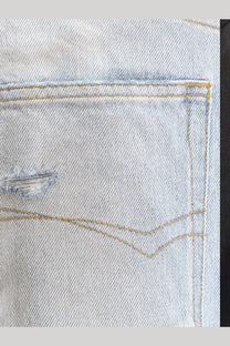 Balenciaga men’s distressed light-wash denim jeans back pocket with frayed tear and tan contrast stitching