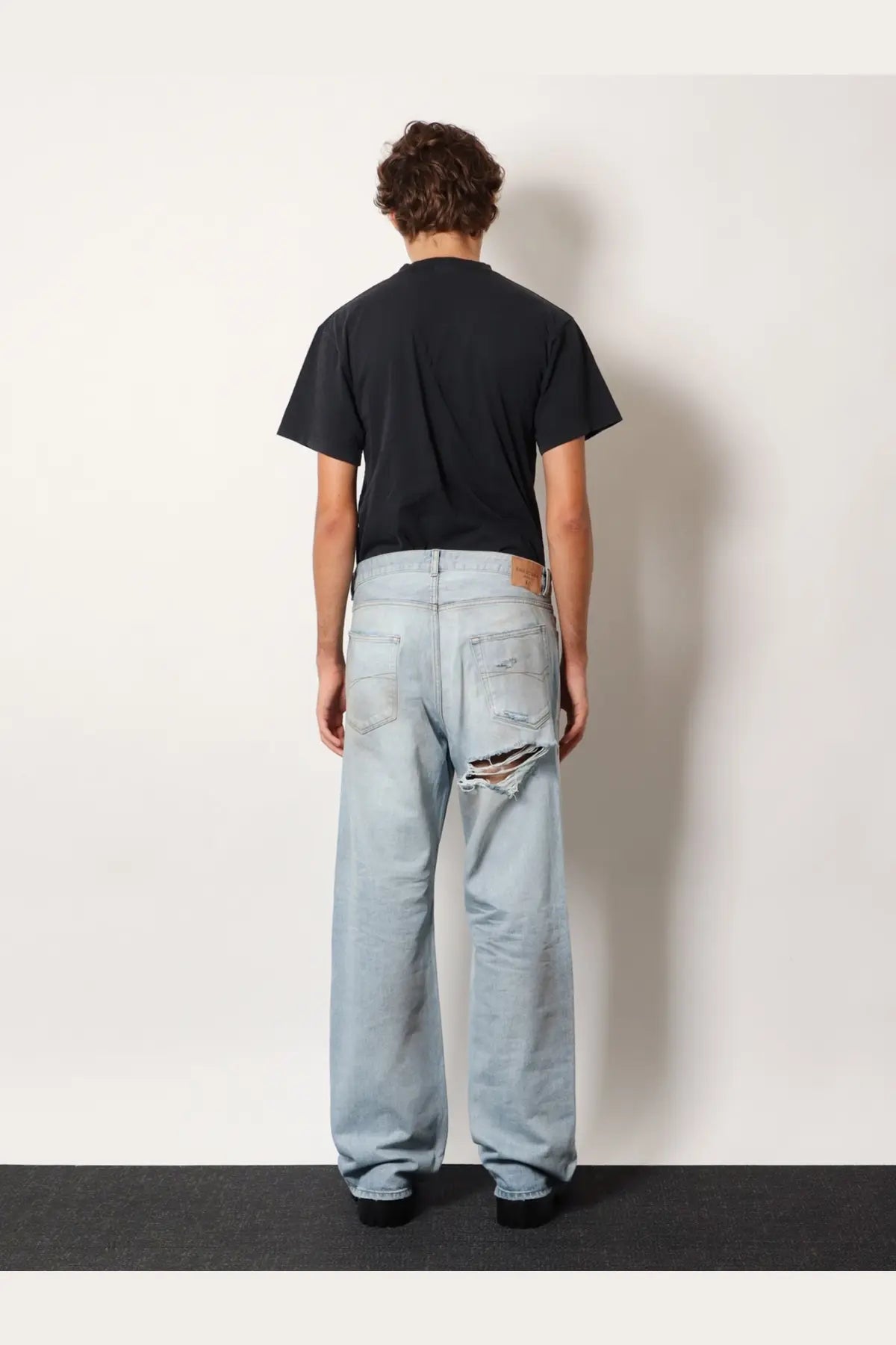 Balenciaga men’s light-wash denim jeans with distressed ripped knee detail in blue