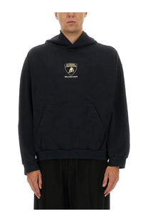 Balenciaga men’s black hoodie featuring a gold and white embroidered Lamborghini logo on the chest
