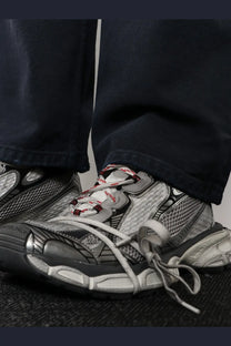 Balenciaga men’s grey mesh sneakers with silver and black mesh upper red and white laces and chunky sole design