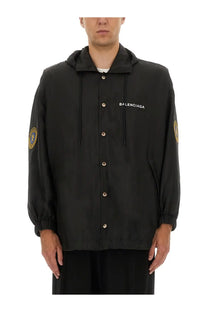 Balenciaga men’s oversized black windbreaker hooded jacket with gold-tone buttons and embroidered sleeve patches