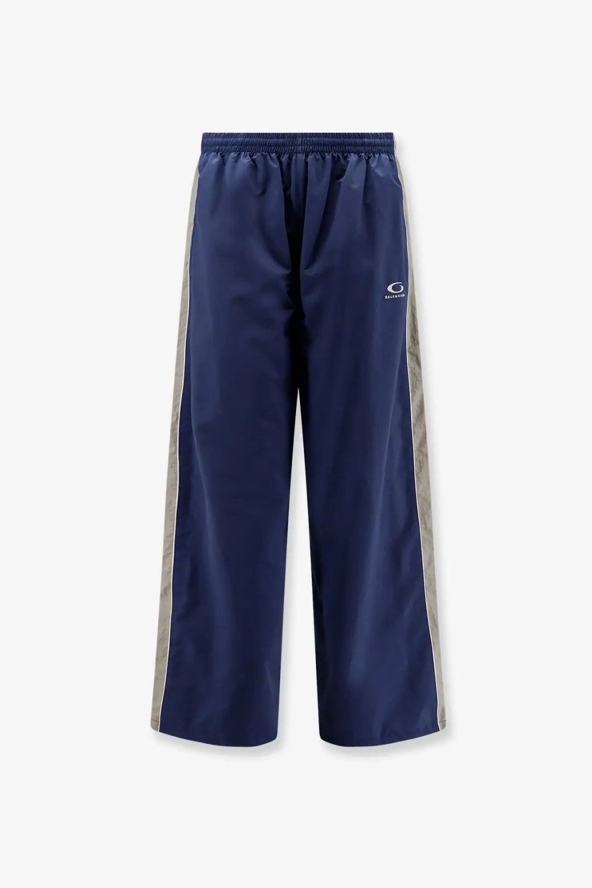 Balenciaga men’s navy blue nylon track pants with silver side stripes and a small white logo on the thigh