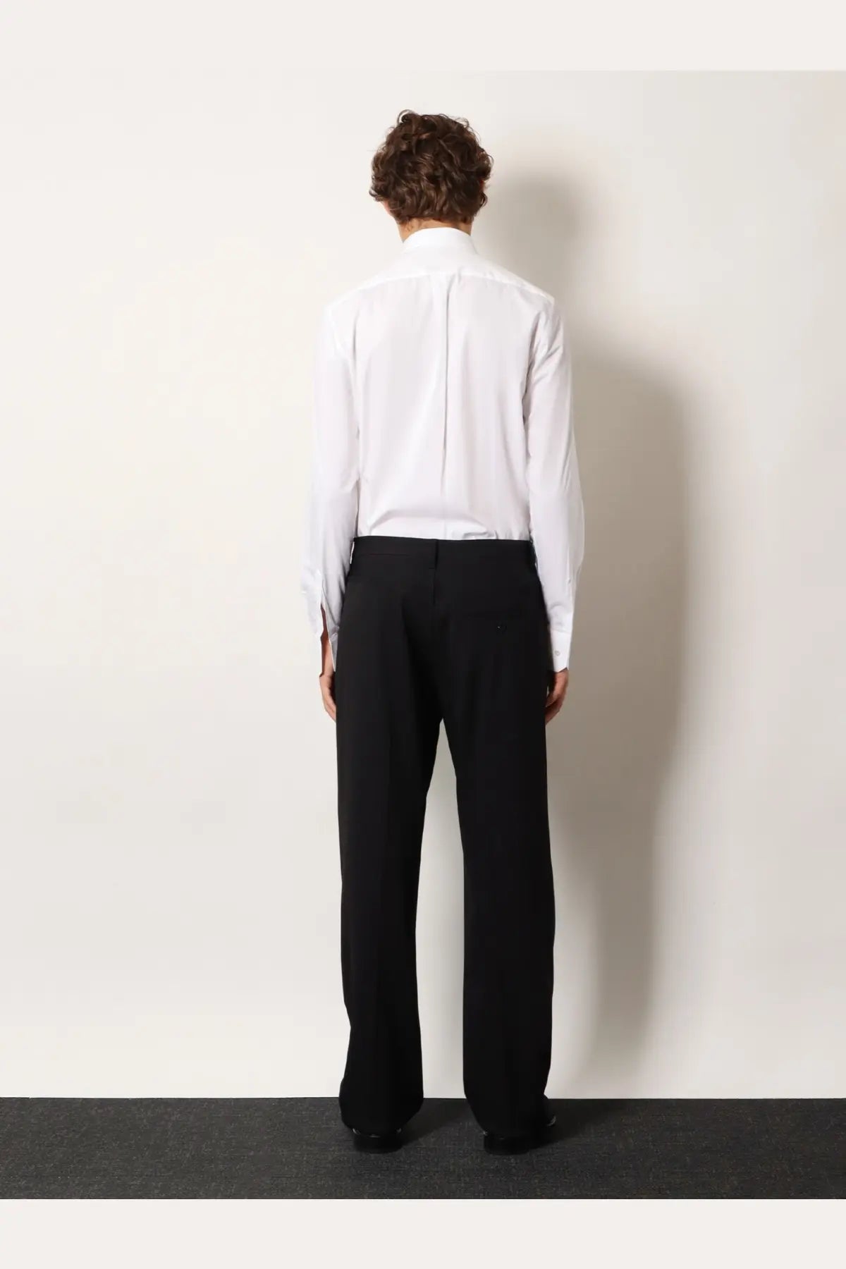 A crisp white long-sleeved dress shirt with classic collar paired with balenciaga men’s straight fit black cotton trousers