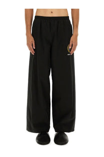 Balenciaga men’s black wide-leg tracksuit pants with drawstring waistband and embroidered logo on left thigh