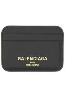 Balenciaga women’s black leather card holder with gold foil branding and compact cash storage design