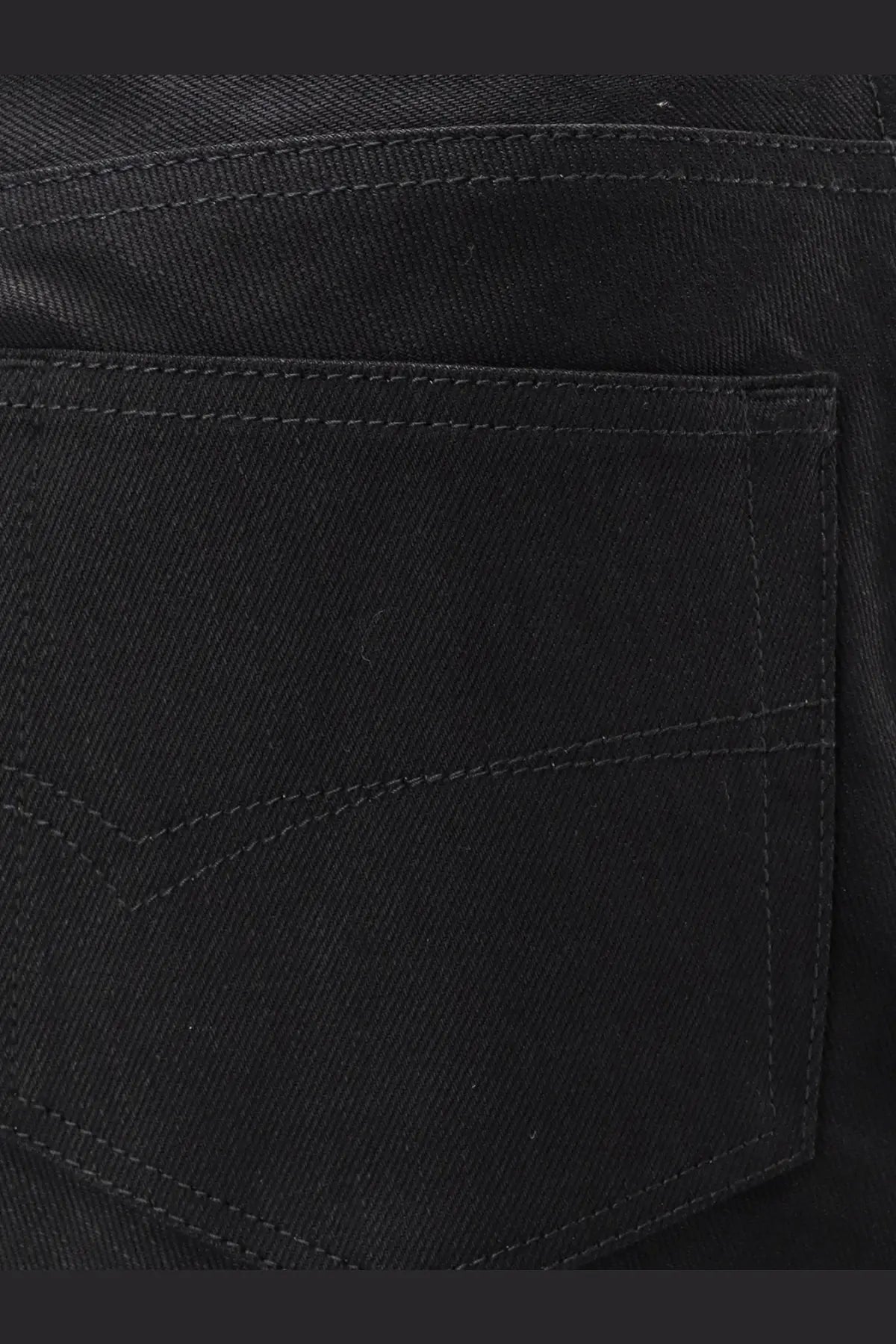 Balenciaga women’s black cotton midi skirt showing back side with subtle stitching on black denim jeans pocket