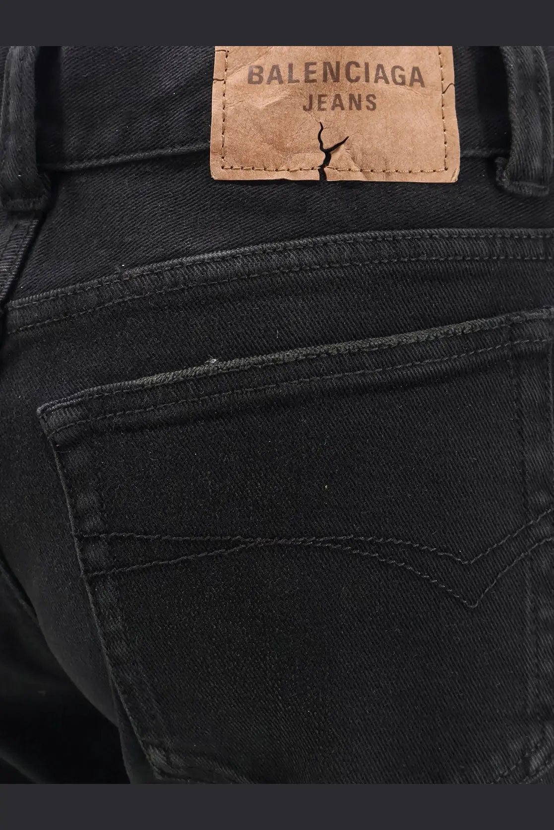 Balenciaga women’s black denim trousers showing back with tan leather patch cracked and stitched balenciaga jeans logo