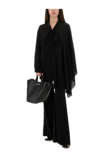 Black balenciaga tote bag with structured silhouette and bold vertical stitching paired with women’s flared pants black