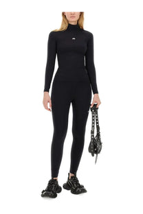 Black balenciaga logo print high neck long sleeve top paired with women’s black leggings displaying front view
