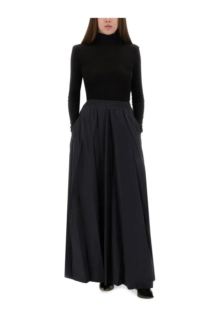 Balenciaga women’s black high-neck long-sleeve top paired with matching pleated maxi skirt in front view