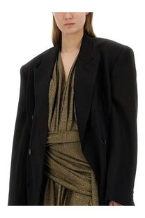 Balenciaga women’s black oversized blazer with structured shoulders and double-breasted buttons over metallic gold dress